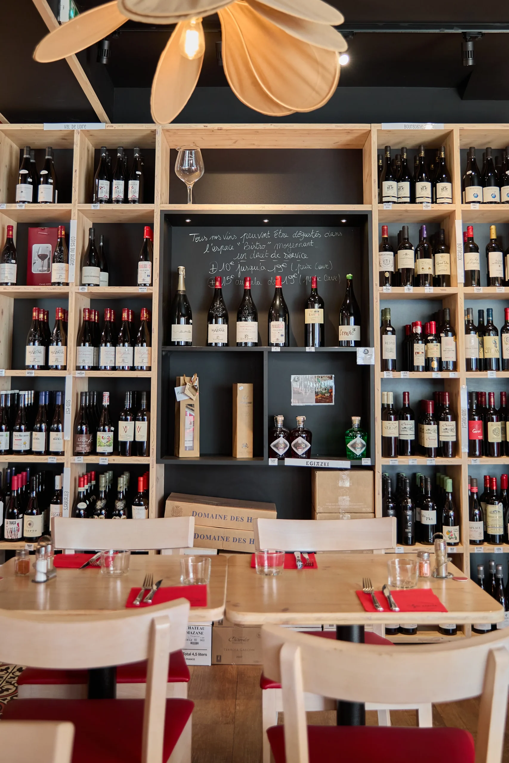 Cave à vin en bois du Bistro Kantxa avec bouteilles de vins rouges et blancs